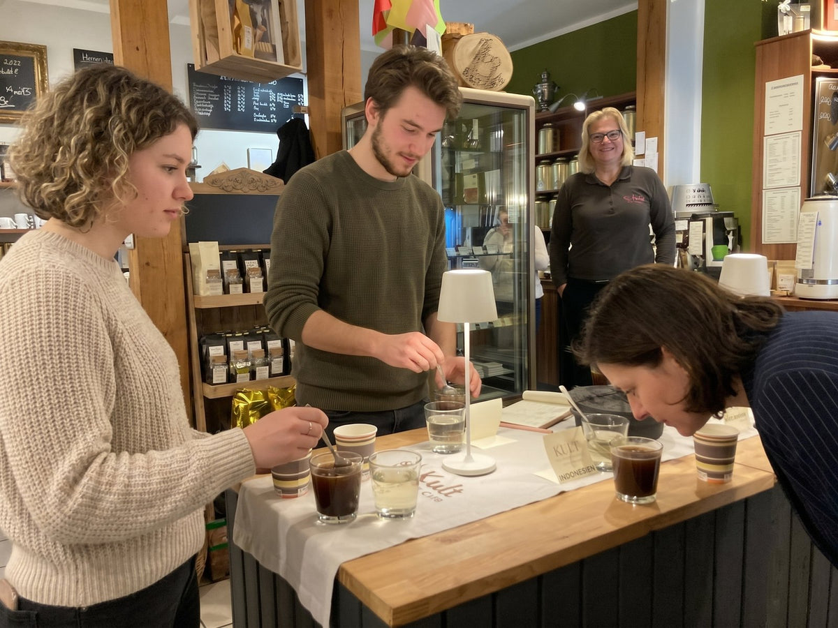 Teilnehmende verkosten Kaffee beim Cupping im Seminar
